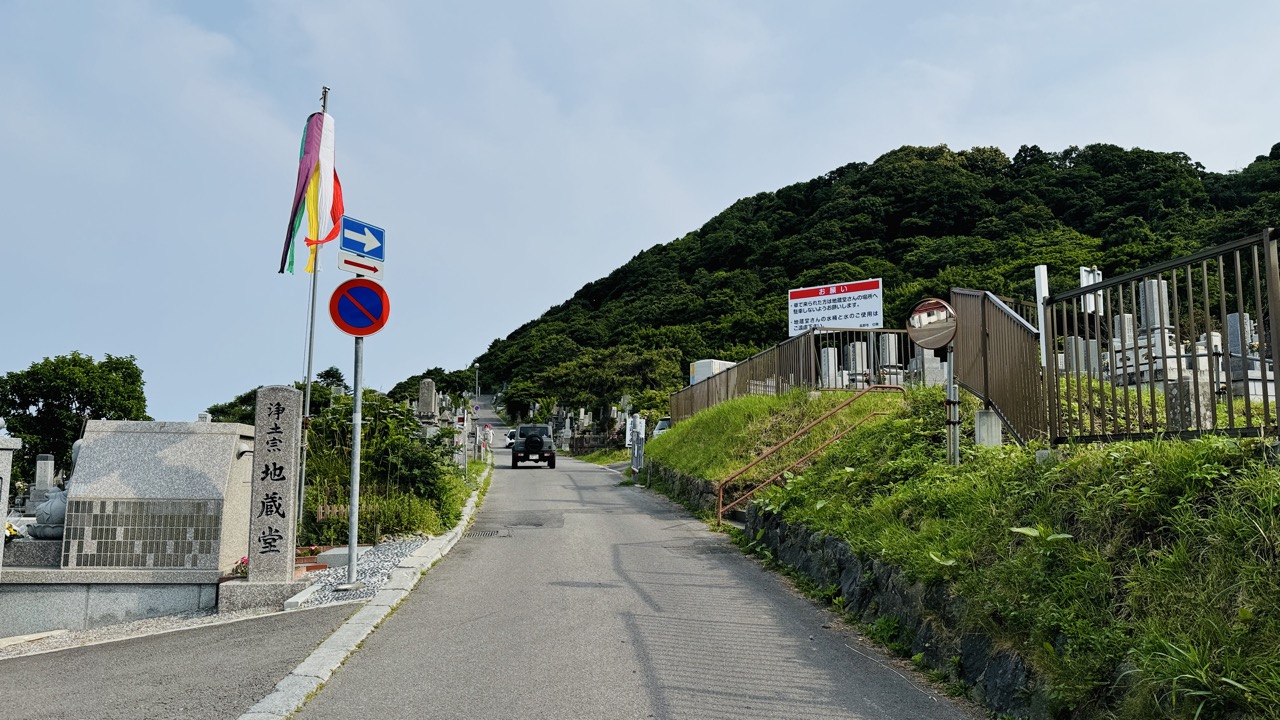 公園を抜けて海沿いの道に出ると前方に上り坂とその先に緑に覆われた函館山が見える