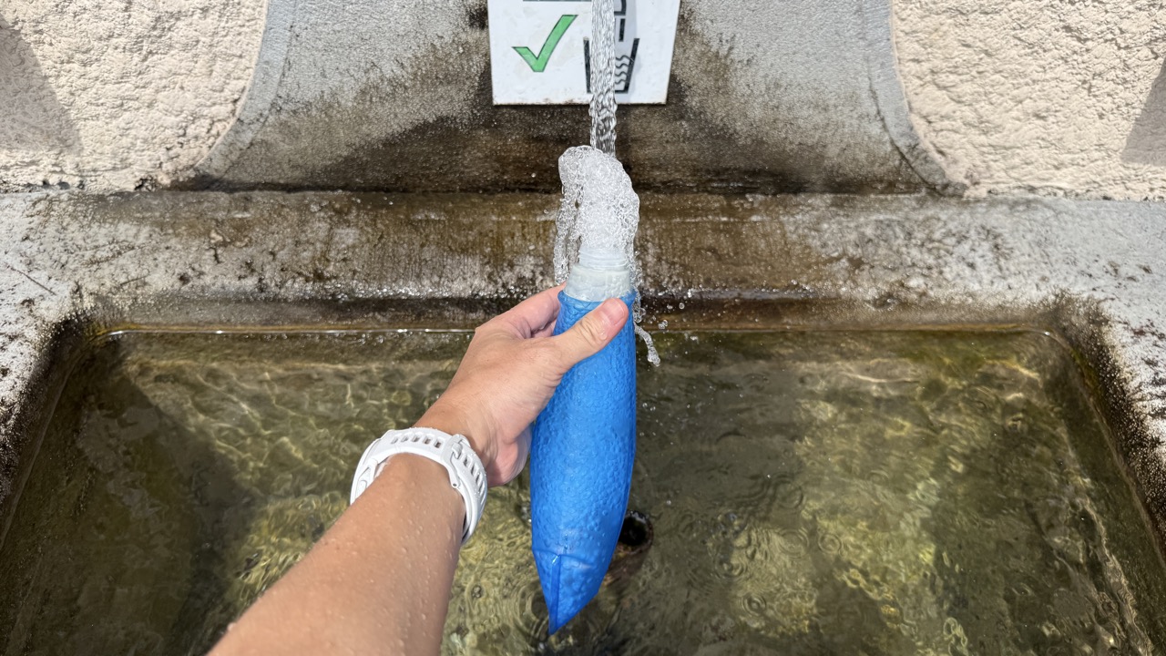 水飲み場で「サロモン」のソフトフラスクに給水する様子