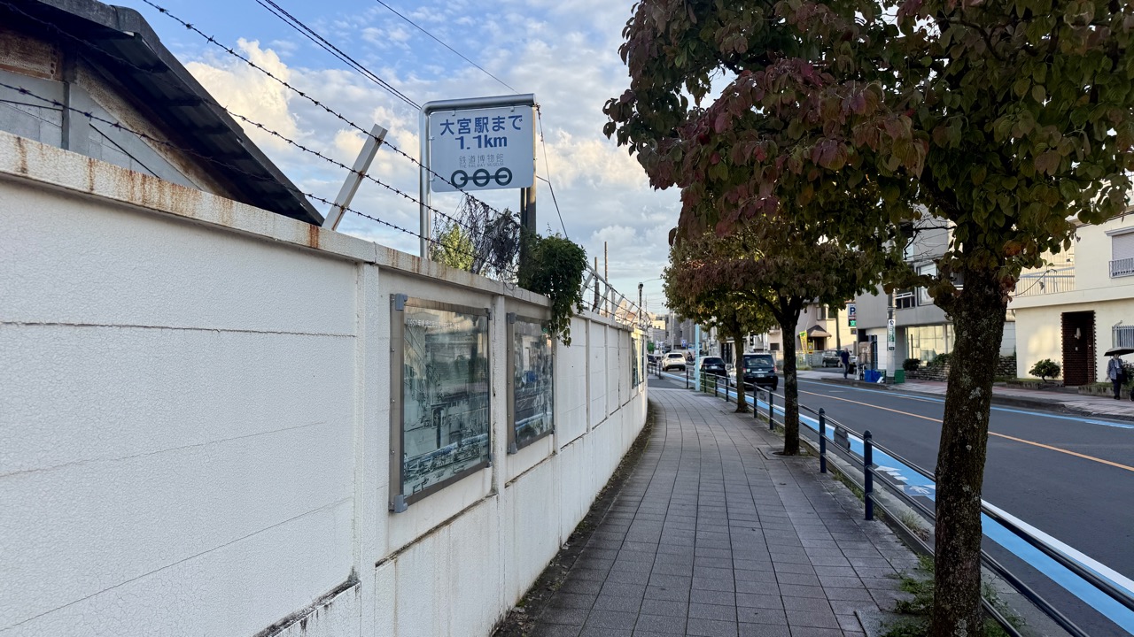 大宮駅まで1.1kmの案内看板と壁面のモノクロ写真展示